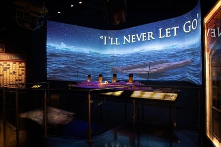Model of the RMS Titanic at the Titanic Museum, with Titanic Movie prop and 'I'll Never Let Go' text.