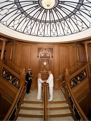 A couple standing on the Grand Staircase saying vows to each other.