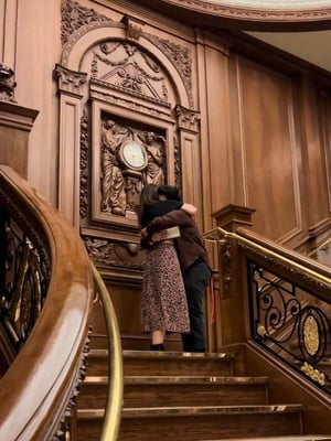 A couple embrace after a proposal on the Grand Staircase at the Titanic Museum Attraction