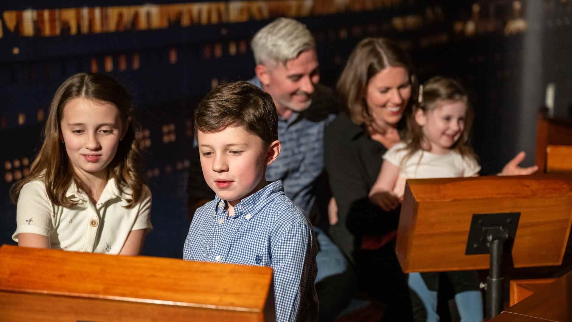 A family sits together in a replica of a Titanic Lifeboat.
